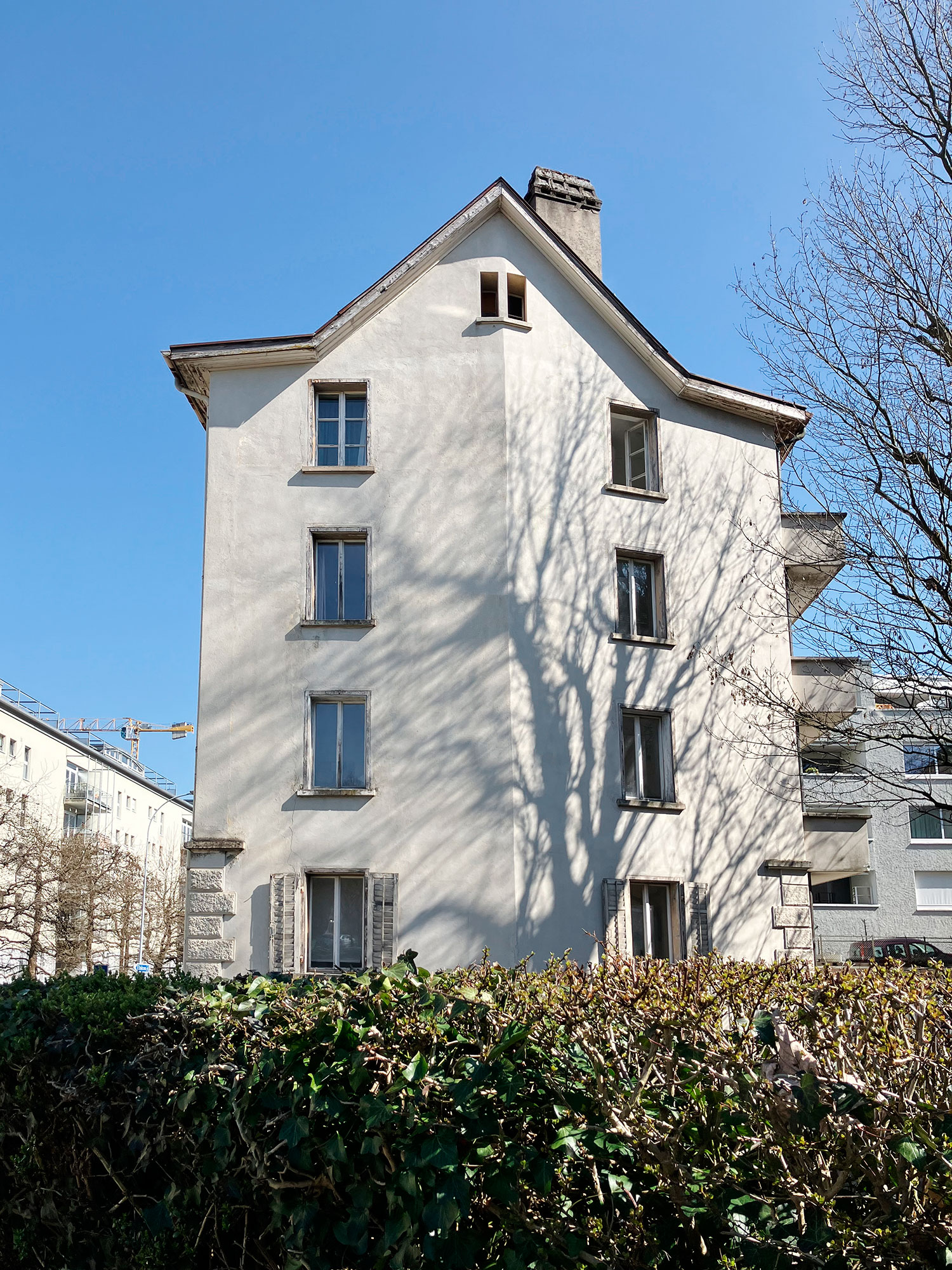 Eine weisse Altbau-Gebäude-Fassade mit 9 Fenstern