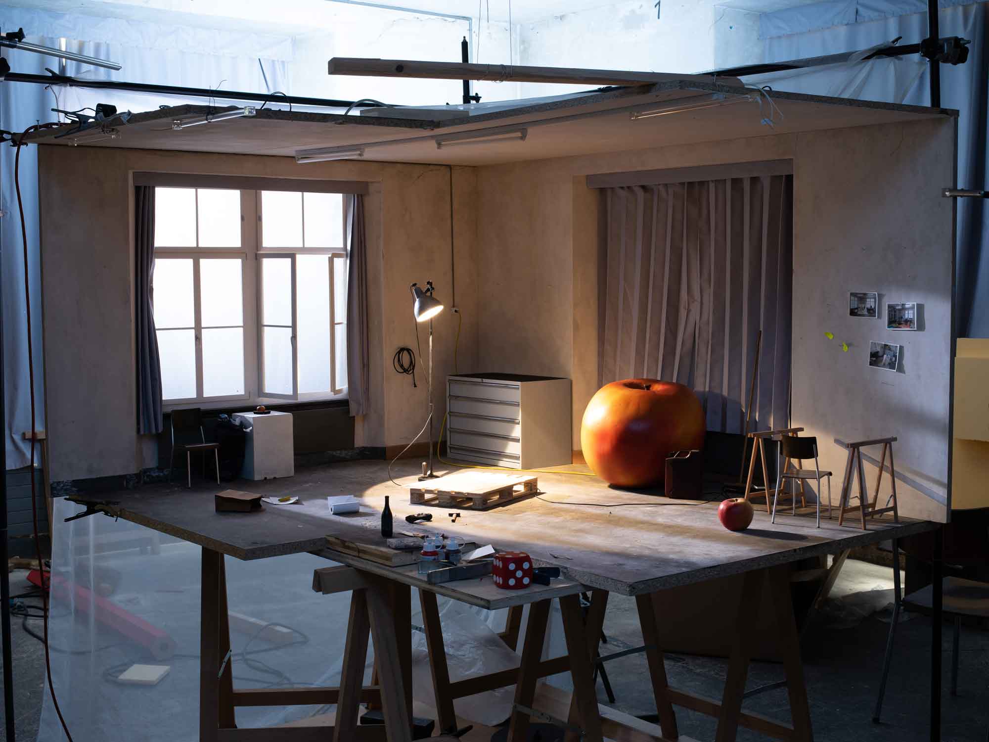 Ein kleines Modell eines Ateliers mit einem originalgrossen Apfel darin. Der Apfel wirk im nachgebauten Raum überdimensional