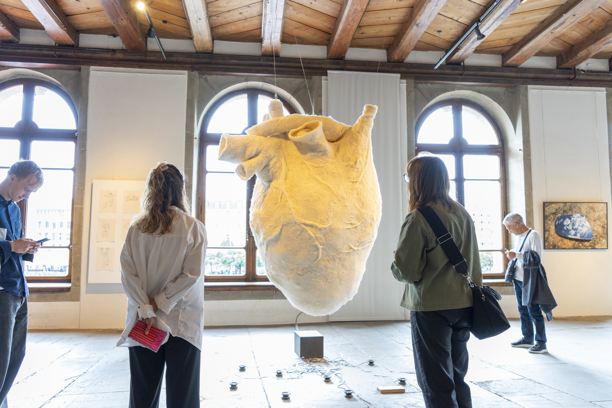 Foto von Mario Grossenbacher Zwei Personen schauen sich eine Skulptur eines riesigen Herzens aus Filz an.