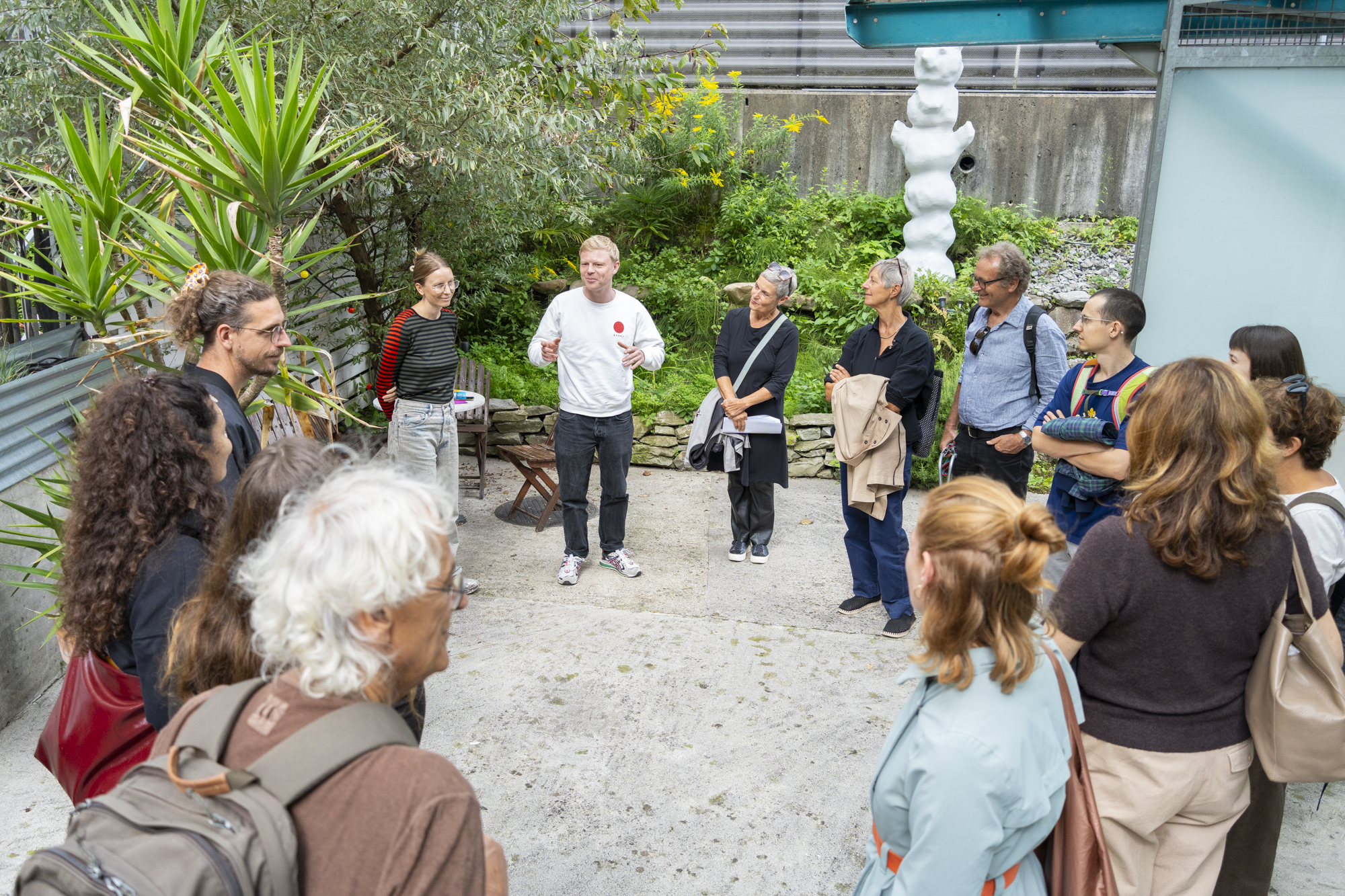 Foto von Mario Grossenbacher Eine Gruppe im Kreis angeordnet erhält nähere Informationen zur Ausstellung