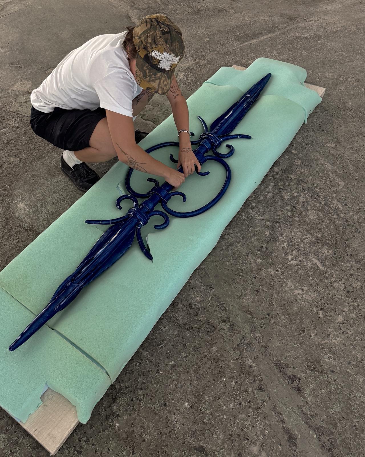 Künstlerin Kika Vilela mit einer blauen Skulptur aus Ton
