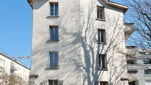 Eine weisse Altbau-Gebäude-Fassade mit 9 Fenstern