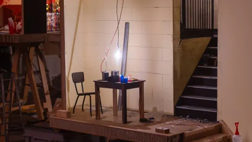 Ein beleuchtetes Modell eines Innenraumes mit kleinem Stuhl steht in einem Raum auf zwei Kisten.