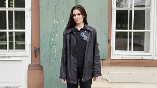 Eleonora Bitterli steht vor einer Hausfassade und schaut in die Kamera. Sie trägt ein koplett schwarzes Outfit.