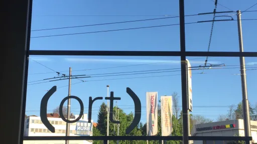 Ein Fensterrahmen - auf der Fensterscheibe steht (ort)