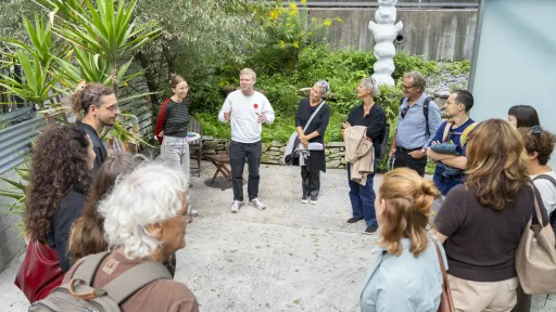 Eine Gruppe im Kreis angeordnet erhält nähere Informationen zur Ausstellung