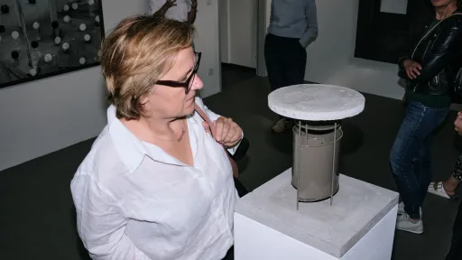 Eine Frau schaut sich eine kleine architektonische Skulptur an